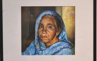 Mixed Media drawing of a woman wearing a blue shawl. Her expression appears tired.
